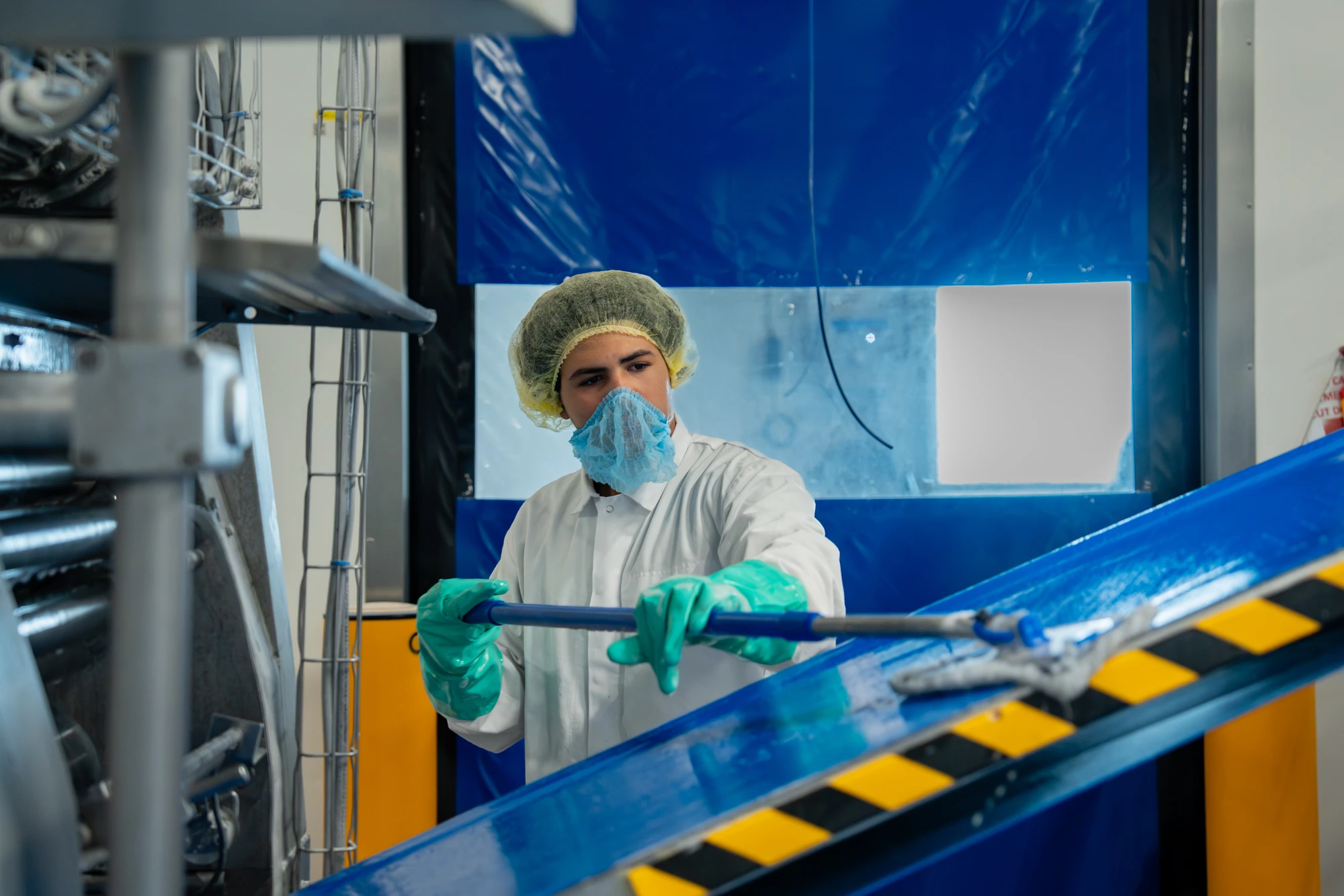 Medewerker in hygiënekleding bij een productielijn