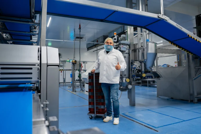 Medewerker van SMB Duiven met schoonmaakkar in een productieomgeving
