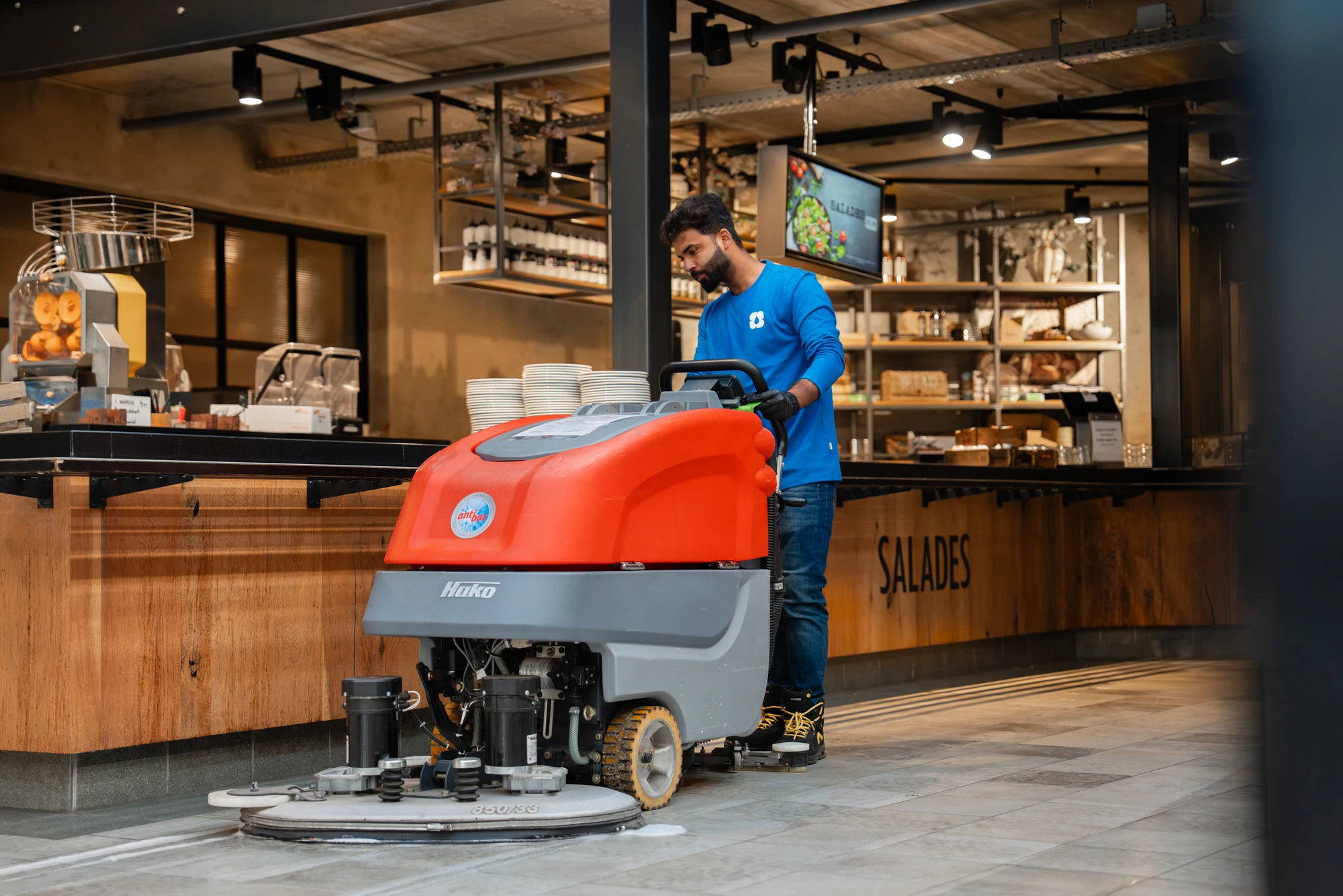 Medewerker met een schrobmachine in een winkel