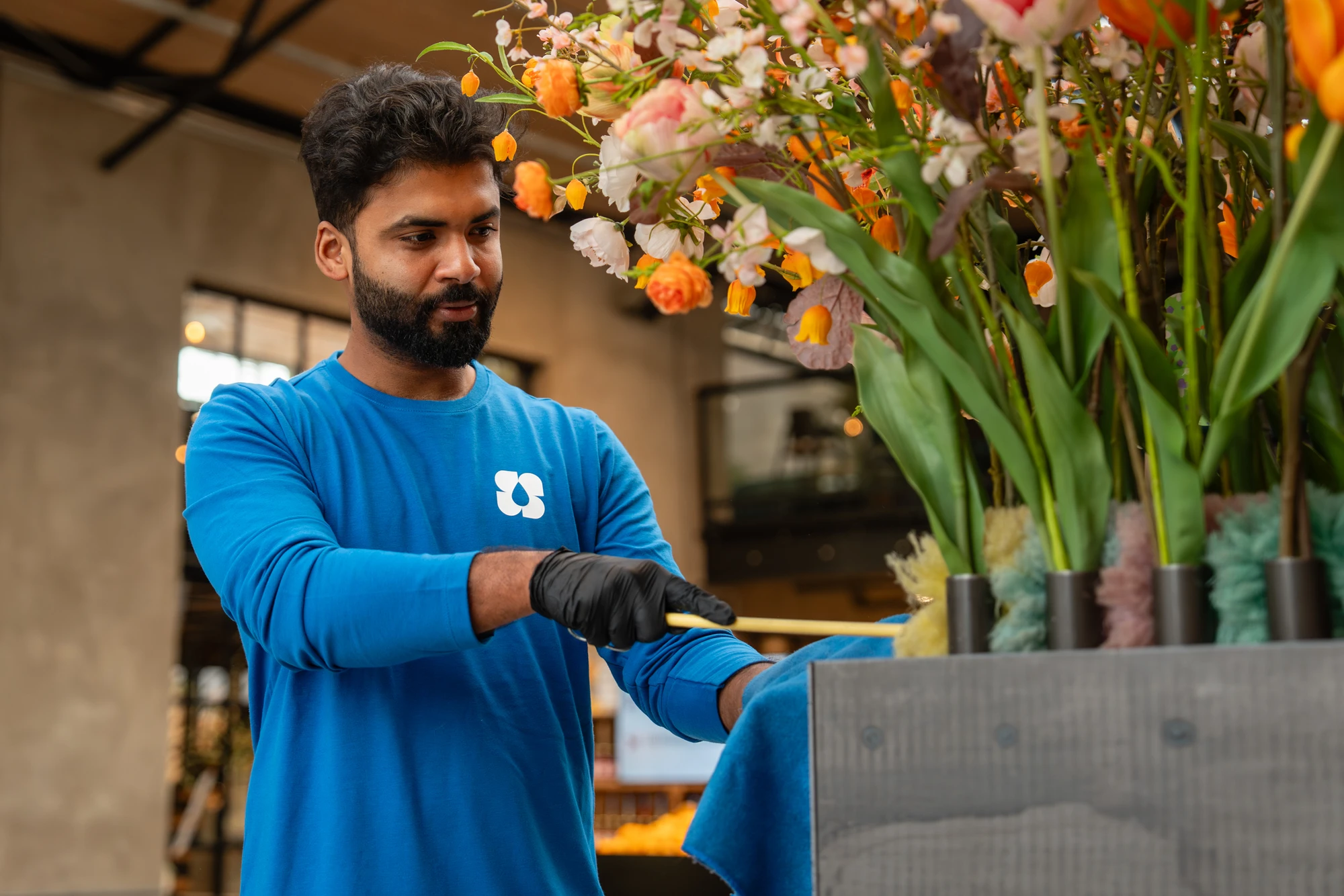 Medewerker van SMB Duiven aan het werk in een winkel met bloemen