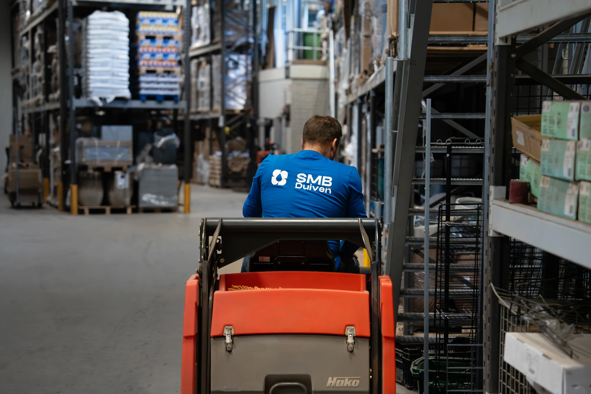 Medewerker van SMB Duiven met schoonmaakmachine in een magazijn