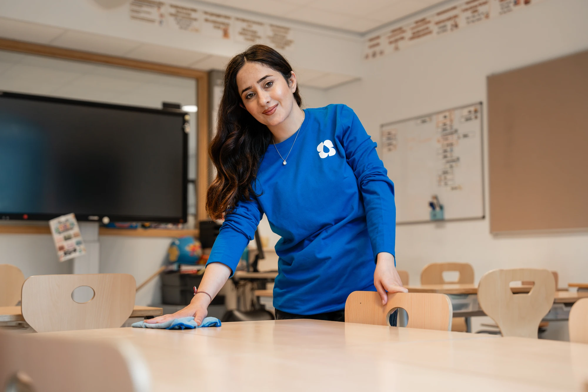 Schoonmaakster maakt een tafel schoon in een vergaderruimte